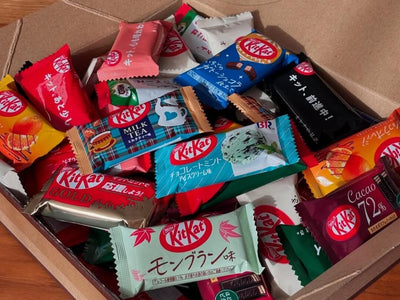 A brown box of various Japanese Kit Kats in different flavors and many designs