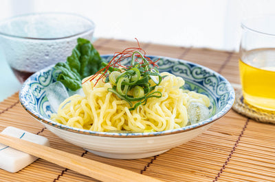 Noodles over ice with cups of tea and dashi.