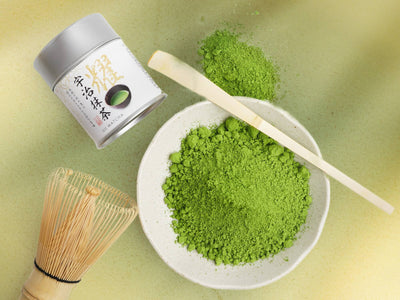 A plate of Uji Matcha powder next to a traditional scooper and whisk