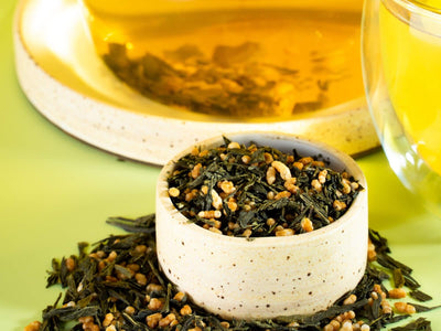 A small bowl of genmaicha (tea leaves and roasted rice) in front of a pitcher